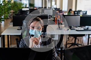 Portrait of a female operator Call Center wearing a medical mask for the desktop