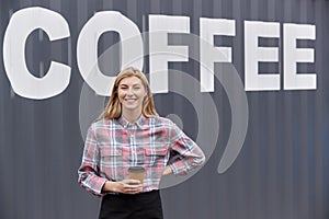 Portrait Of Female Owner Of Coffee Shop Or Distribution Business Standing By Shipping Container