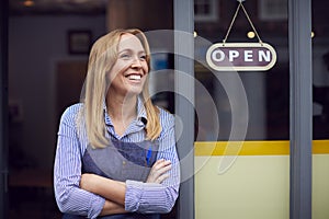 Portrait Of Female Owner Or Staff Standing Outside Shop Or Store With Open Sign