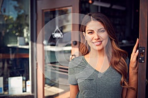 Portrait Of Female Owner Of Start Up Coffee Shop Or Restaurant Standing In Doorway