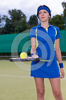 Portrait of a female player holding a tennis ball on her racket