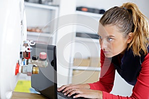 portrait female plumber working on central heating boiler