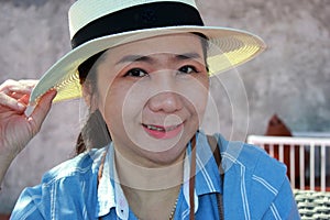 Portrait of female protrait in white hat and looking away.