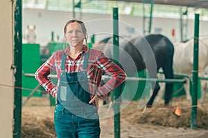 Portrait of female rancher at horse stable looking at camera