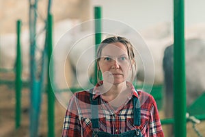 Portrait of female rancher at horse stable looking at camera