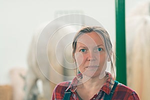 Portrait of female rancher at horse stable looking at camera