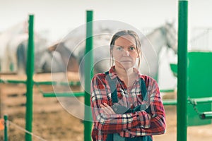 Portrait of female rancher at horse stable looking at camera