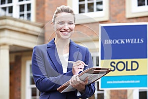 Portrait Of Female Realtor Standing Outside Residential Property