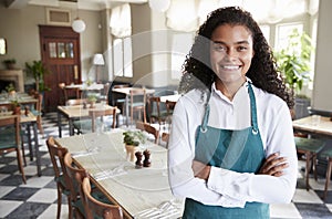 Portrait Of Female Restaurant Manager In Empty Dining Room