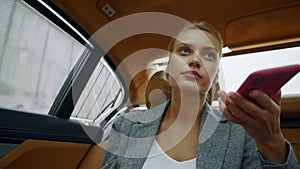 Portrait of female riding at backseat at car. Woman calling mobile phone at car