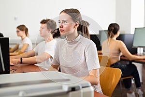 Portrait of female schoolgirl at computers in university class