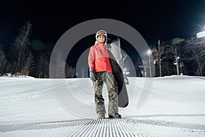 Portrait of female snowboarder at evening slope. Winter sports concept