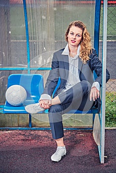 portrait of female soccer coach with ball at the stadium.
