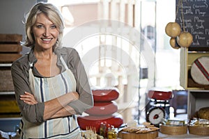 Portrait of female staff standing with arms crossed at counter