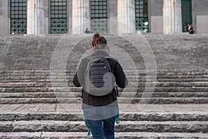 Portrait of a female student on her back walking up the stairways