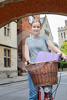 Portrait Of Female Student Riding Old Fashioned Bicycle Around Oxford University College Buildings By Bridge Of Sighs