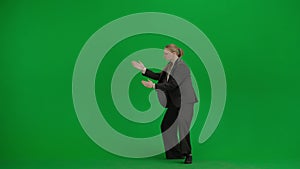Portrait of female in suit on chroma key green screen. Blonde business woman in formal outfit dancing old school techno