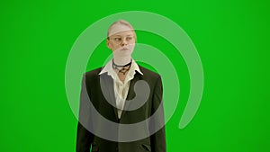 Portrait of female in suit on chroma key green screen. Blonde business woman in formal outfit walking with confident