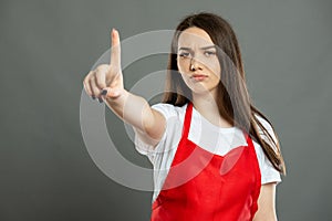 Portrait of female supermarket employee making wait a minute gesture