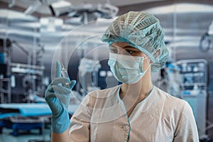 Portrait of female surgeon or assistant wearing surgical mask in operating theatre room