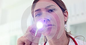 Portrait of female surgeon doctor with flashlight in hand