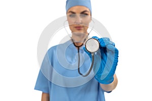 Portrait of female surgeon holding stethoscope against white background