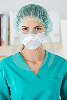 Portrait of female surgeon wearing protective mask and cup