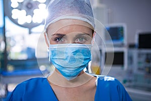 Portrait of female surgeon wearing surgical mask in operation theater