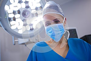 Portrait of female surgeon wearing surgical mask in operation theater