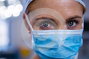 Portrait of female surgeon wearing surgical mask in operation theater