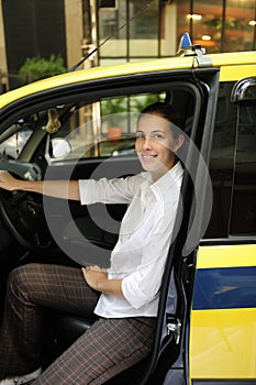 Portrait of a female taxi driver with her new cab