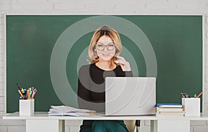 Portrait of female teacher is teaching online through webcam students with computer laptop in classroom.