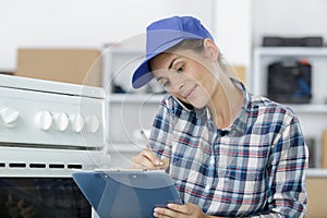 Portrait female technician writing in clipboard