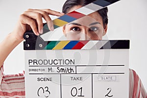 Portrait Of Female Videographer Holding Clapper Board On Video Film Production In White Studio