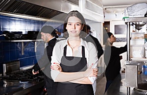 Portrait of female waiter who is standing with order on kitchen
