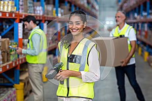 Portrait of female warehouse worker standing with barcode scanner