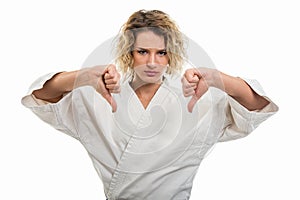 Portrait of female wearing martial arts uniform showing double dislike gesture