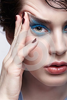 Portrait of female Woman with unusual beauty makeup and wet hair, and blue shadows make-up
