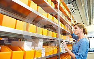 Portrait of a female worker organizing boxes on shelves