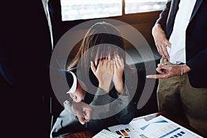 Portrait of a female worker showing failure at work and being reprimanded by a colleague photo