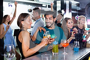 Portrait of females and males having fun in the bar