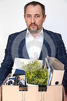 Portrait of a fired mid-level manager holding a box of office supplies. Vertical photo. Isolated on a white background