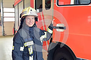 portrait of a firefighter at the emergency vehicle in the fire station