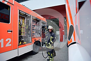 portrait of a firefighter at the emergency vehicle in the fire station