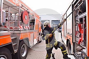 portrait of a firefighter at the emergency vehicle in the fire station