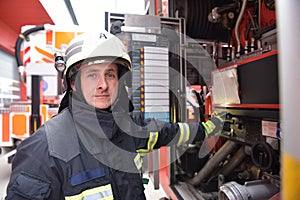 portrait of a firefighter at the emergency vehicle in the fire station
