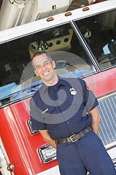 Portrait of a firefighter by a fire engine