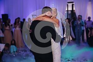 Portrait of first dance of stylish wedding couple. Handsome groom and elegant bride in the restaurant