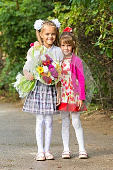 Portrait first grader and her younger sister on way to school