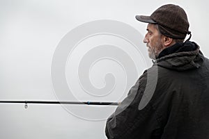 Portrait of fisherman with fishing rod on autumn day